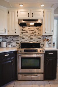 Before and after kitchen photos of two tone painted cabinetry