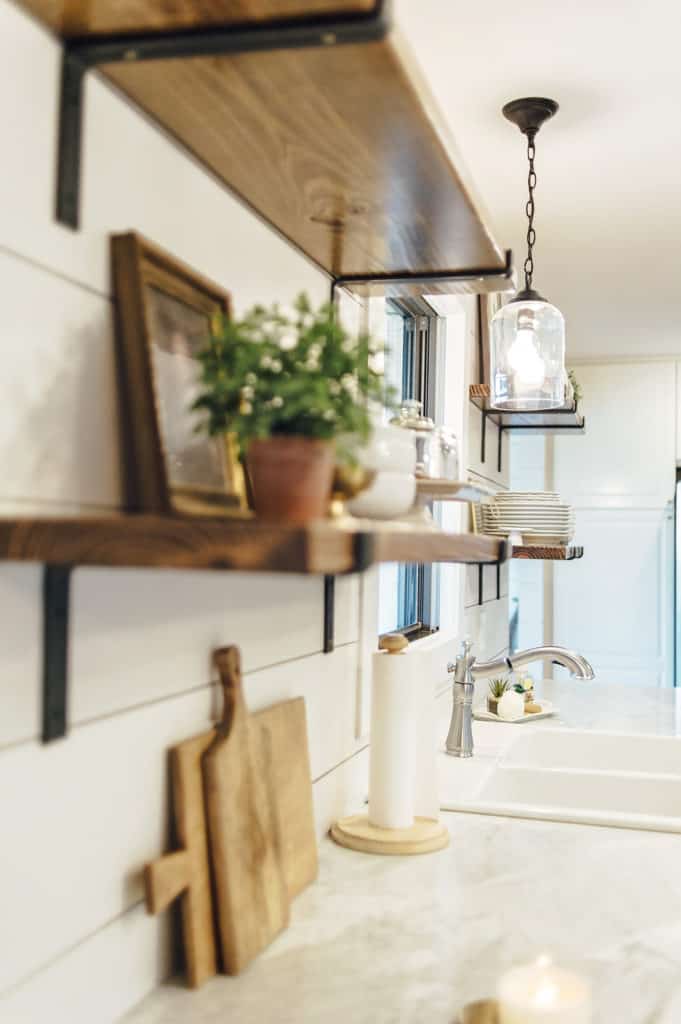 Open shelving in Kitchen with shiplap walls and marble countertops