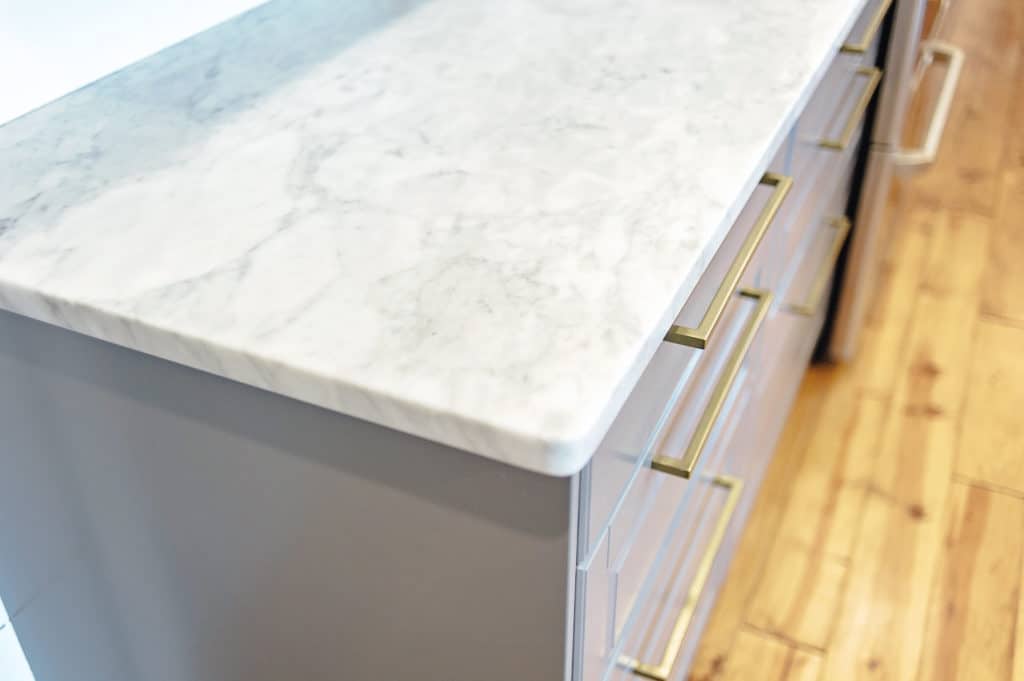 Carrara Marble Counter Top and brass hardware on Ikea Cabinets