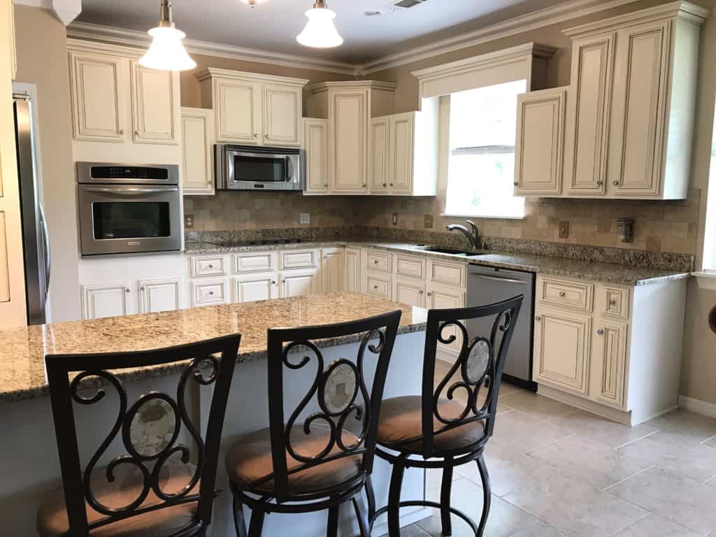 Professionally painted and glazed cabinets. Sherwin Williams Steamed Milk transformed a dark and dated kitchen into a bright and updated kitchen!