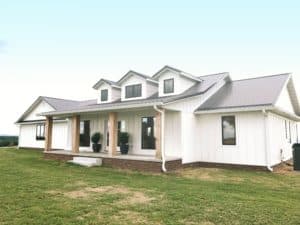 White board and batten modern farmhouse with black metal roof.