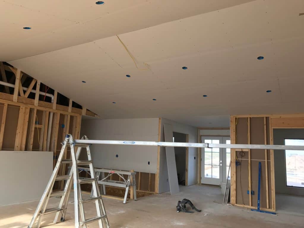 Installing sheetrock on vaulted ceiling.