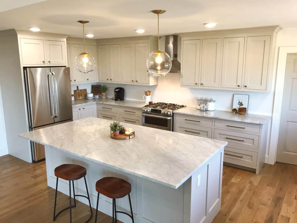 Beautiful modern farmhouse kitchen complete with inset shaker style cabinet doors and Carrara marble countertops. Brass hardware and light fixtures lend and updated yet classic look. 