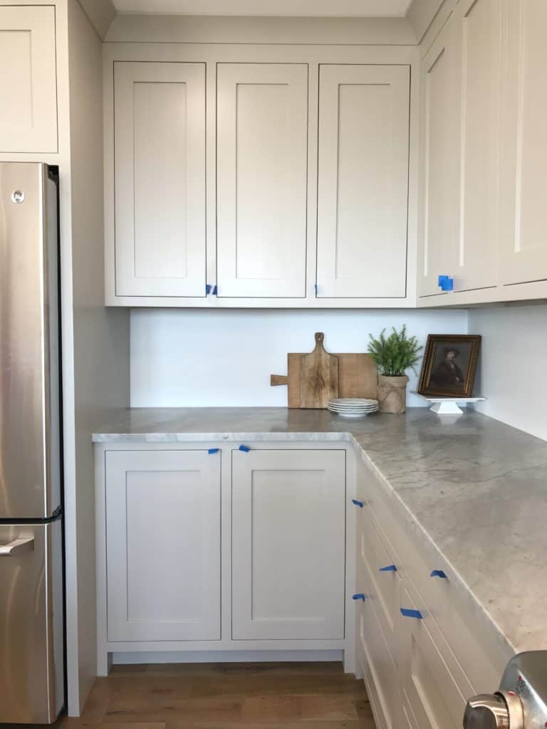 Shaker style inset cabinet doors painted in Revere Pewter. Honed marble countertops add a sophisticated feel to this modern farmhouse kitchen.