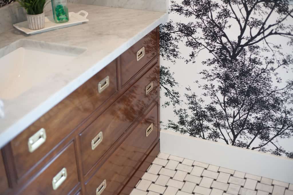 Black and white tree silhouette wallpaper in powder bathroom.