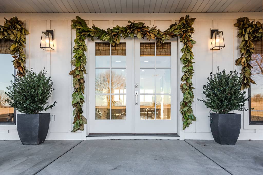 Fresh Magnolia Garland around front door and windows makes a simple, Christmas front porch!