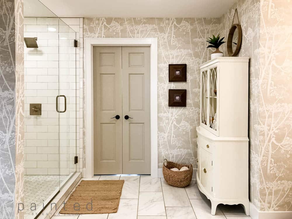 Traditional modern master bathroom decor. Cole & Son Cow Parsley wallpaper and pretty storage options in the bathroom