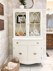High gloss white painted china cabinet provides beautiful storage in the master bathroom!