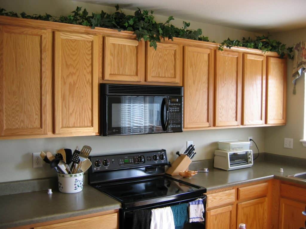 kitchen decor. how to decorate above kitchen cabinets. faux plants above cabinets. using ivy above cabinets. kitchen decor ideas. country kitchen decor ideas. 5 kitchen decor items to ditch