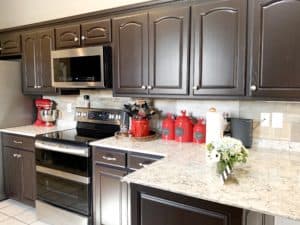 It's true, not everyone wants white cabinets! Dark brown espresso painted kitchen cabinets gives this 90's oak kitchen a modern facelift.