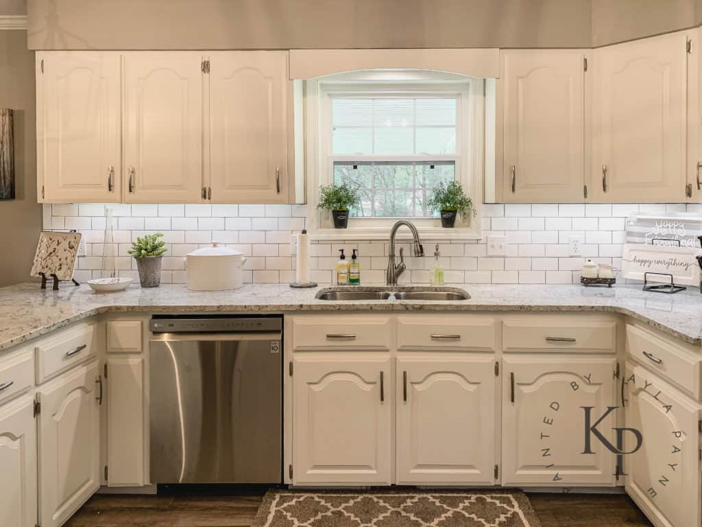 Kitchen Cabinets painted in Sherwin Williams Alabaster with white subway tile backsplash and granite countertops