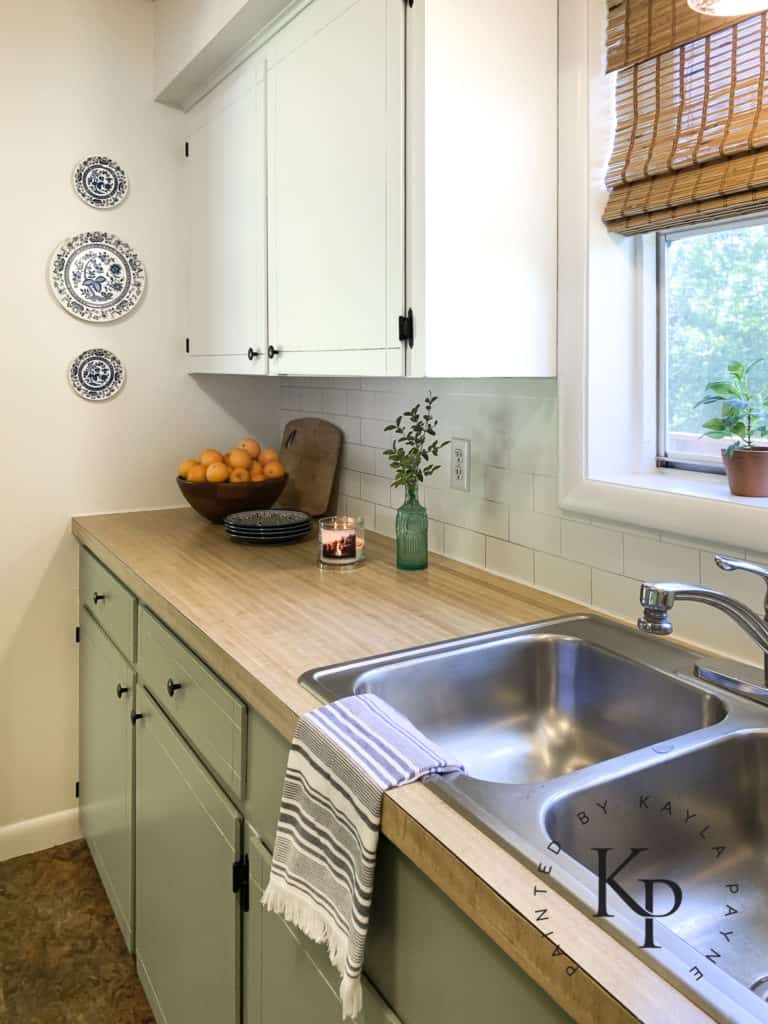 faux wood countertops with painted cabinets, fake butcher block counters with painted cabinets, green kitchen cabinets, sherwin williams green onyx, sherwin williams ivory lace cabinets, two ton cabinets, cheap kitchen makeover