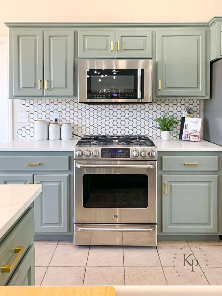 green kitchen cabinets with stainless steel appliances