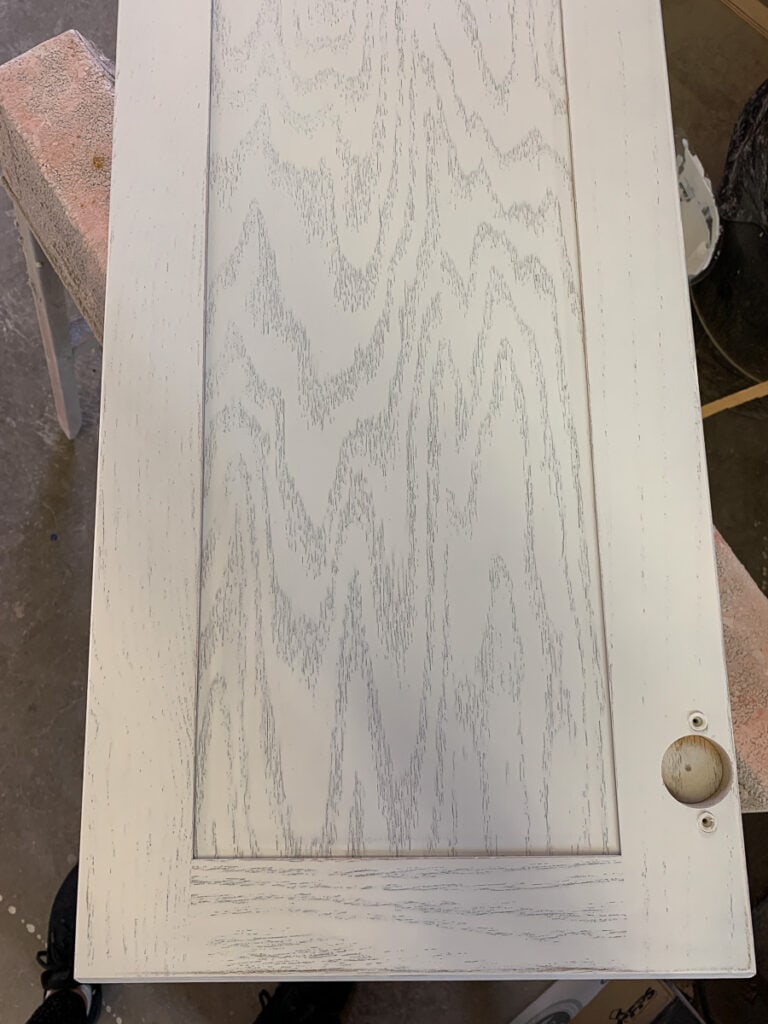 Oak grain on cabinet door with paint that was sprayed on.
